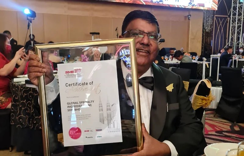 GSI representative holding the SME100 award certificate in 2021